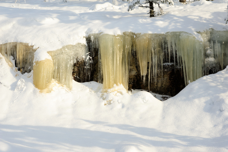 Icicles hanging from a rock cliff. Snowy landscape in Koli National park, Finlandの写真素材