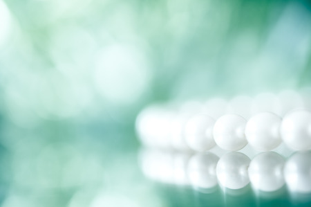 White pearl necklace on a glass table.  Selective focus and shallow depth of field.の写真素材