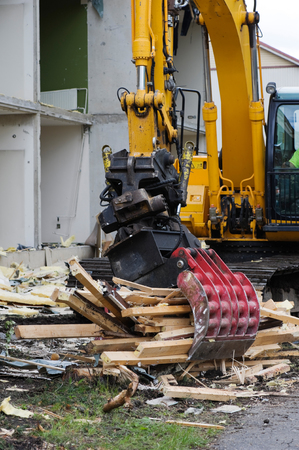 Excavator with grab breaking down a house.の写真素材
