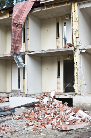 Pile of bricks in front of partially demolished house.の写真素材