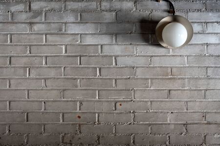 Old electric lamp inÂ the garage brick wall