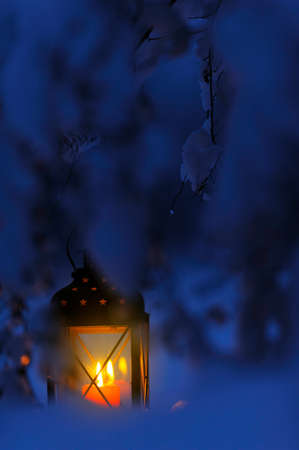 Candle lantern in snow at duskの写真素材