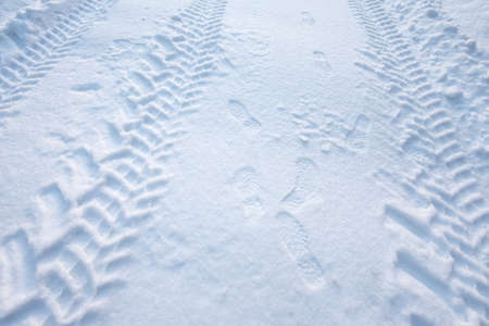 Tire tracks and footprints in fresh snowの写真素材