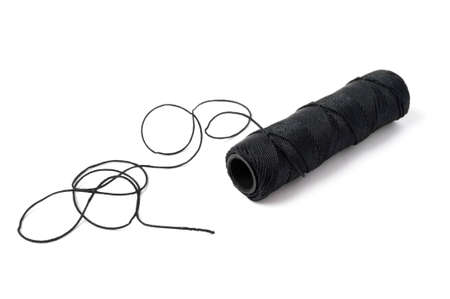 Spool of black string on white background.の写真素材
