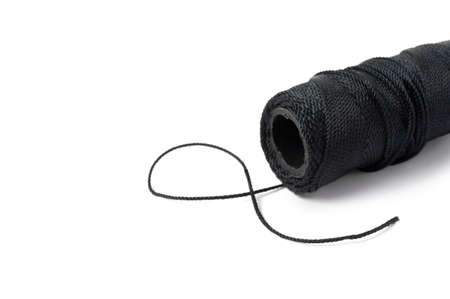 Spool of black string on white background.の写真素材