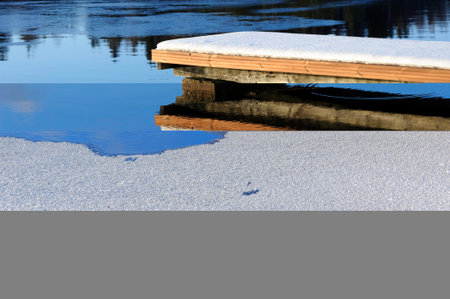 Winter at lake shore, pier covered with fresh snow.の写真素材