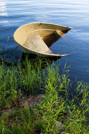 Sunken small motor boat on the shoreの写真素材