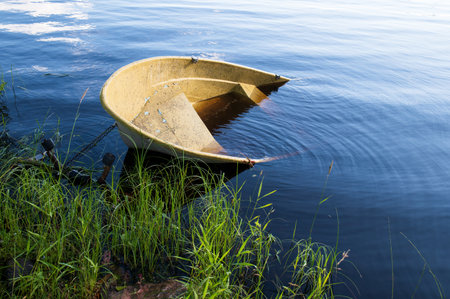 Sunken small motor boat on the shoreの写真素材