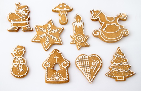 Homemade Christmas Ginger and Honey cookies on white background. Star, fir tree, snowflake, horse, bell, mushroom, Santa Claus, snowman, rocking horse, candle, heart - shapes.の写真素材