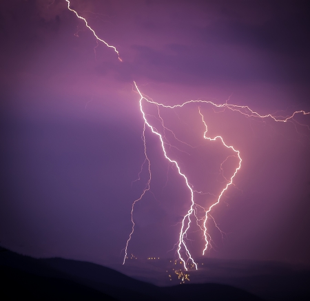 Smashing lightning during a storm over the small city in the valley - lightning struck right in the cityの写真素材