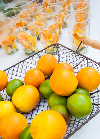 Citrus fruits in basket ready to make juice with glasses in the backgroundの写真素材