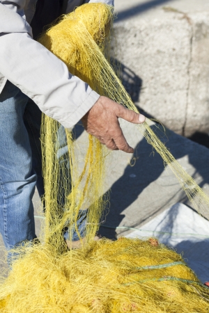 Fishermen casting nets near by a port, under blue skyの写真素材