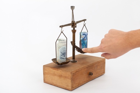 Euro and Greek drachma on a scale in studio isolated on white backgroundの写真素材