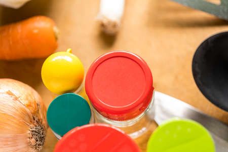 seasonings and cooking utensils on a wood grain cutting boardの写真素材