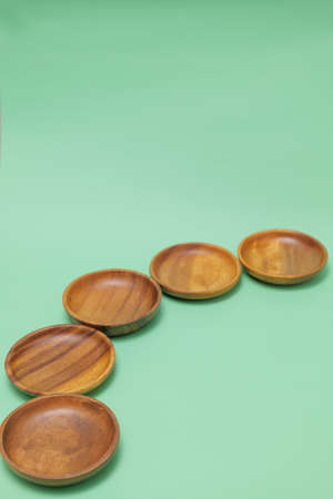 a round wooden dish placed on a green background