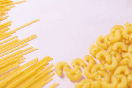 Short pasta and long pasta with pink backgroundの写真素材