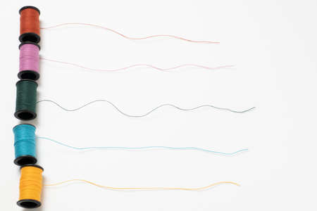 Colorful sewing thread placed on a white backの写真素材
