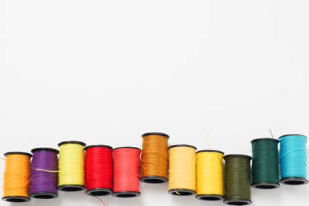 Colorful sewing thread placed on a white backの写真素材