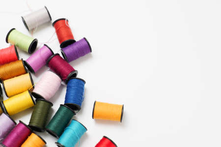 Colorful sewing thread placed on a white backの写真素材