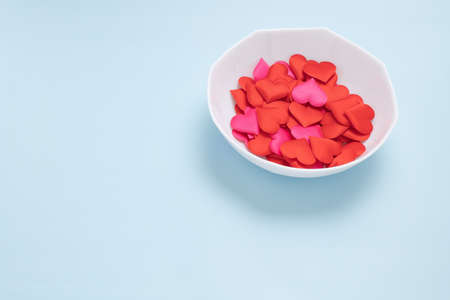 A white dish and a heart-shaped sponge on a blue backgroundの写真素材