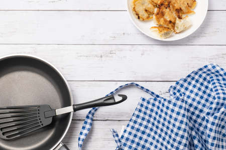 Image of cooking gyoza with white wood grain in the backgroundの写真素材