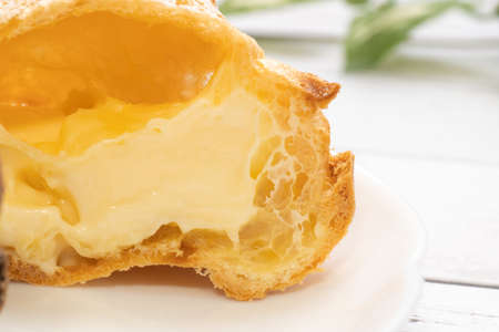 Two kinds of cream puffs on a white plateの写真素材