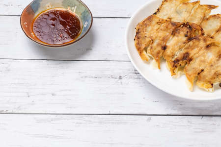 dumplings on a white dish with a white wood grain backgroundの写真素材