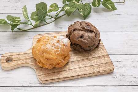 Two types of cream puffs on the cutting boardの写真素材