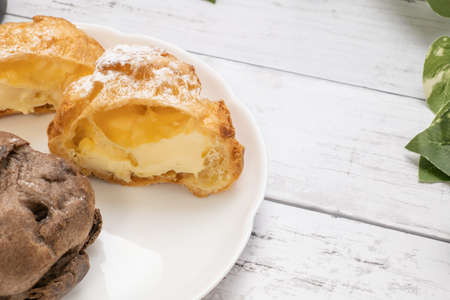 Two kinds of cream puffs on a white plate