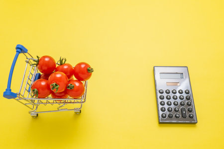Mini tomatoes and calculator on cartの写真素材