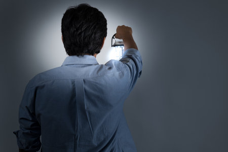 Middle-old man looking for a way out with a lantern in a dark worldの写真素材