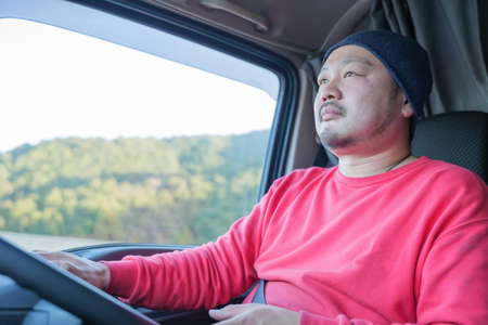 Male driver driving heavy truckの写真素材