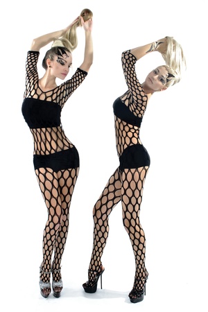 Beautiful girl in acrobatic poses posing on a white background in sexy costumes の写真素材