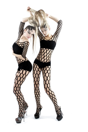 Beautiful girl in acrobatic poses posing on a white background in sexy costumes の写真素材