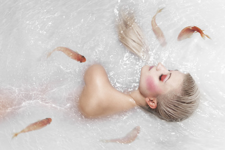 portrait of beautiful mermaid girl with fish tail and long blond hair swimming in ocean magic mythology being original photo compilationの写真素材