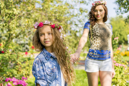 Beautiful Mother And her little daughter outdoors. Nature. Beauty Mum and her Child playing in Park together. Outdoor Portrait of happy family. Happy Mother's Day Joy. Mom and Baby.の写真素材