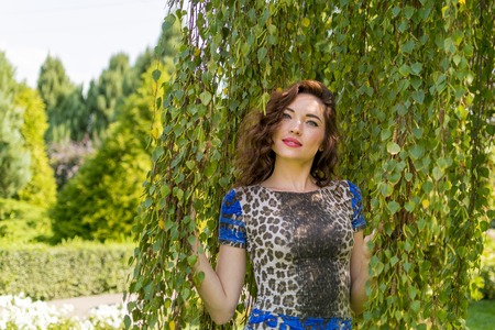 Summer girl portrait. Asian woman smiling happy on sunny summer or spring day outside in park by lake. Pretty mixed race Caucasian young woman outdoors.の写真素材
