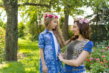 Beautiful Mother And her little daughter outdoors. Nature. Beauty Mum and her Child playing in Park together. Outdoor Portrait of happy family. Happy Mother's Day Joy. Mom and Baby.の写真素材