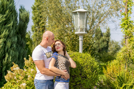 Portrait of love couple embracing outdoor in park looking happyの写真素材