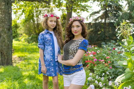 Beautiful Mother And her little daughter outdoors. Nature. Beauty Mum and her Child playing in Park together. Outdoor Portrait of happy family. Happy Mother's Day Joy. Mom and Baby.の写真素材