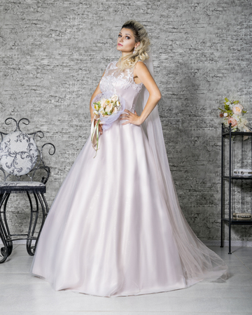 Girl model with professional make-up and hairstyle posing in chic outfits on a wedding backgroundの写真素材