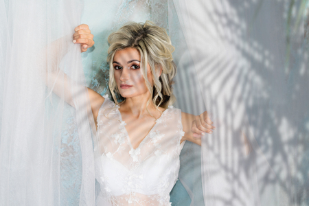 Portrait of a girl in the shadow of branches in a wedding boudoir somewhere in the tropicsの写真素材