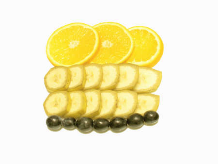 Slices of the orange, banan and a grape against a white background.    の写真素材