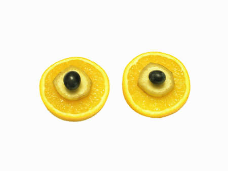 Slices of the orange, banan and a grape on each other against a white background.       の写真素材