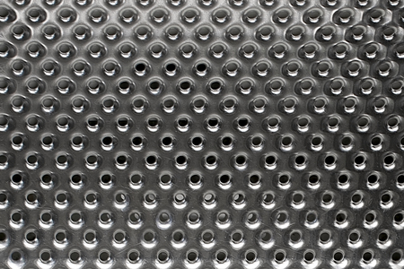 Surface of steel inner drum of washing machine. Metal with holes