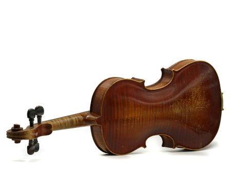 Back of an old scratched wooden violin isolated on white backgroundの写真素材