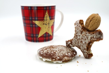 gingerbread man with walnut head and christmas cup in background
