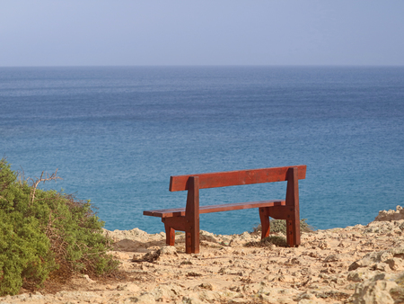 single bench in the park Cavo Greco in Ayia Napa, cyprus overlooking the mediterranean Seaの写真素材