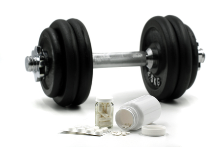 Sports supplements for bodybuilding with dumbbell on background isolated on whiteの写真素材
