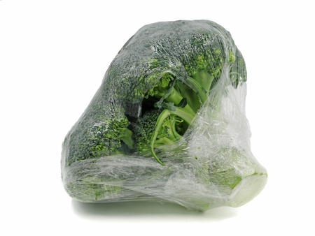 Broccoli wrapped in plastic foil isolated on white backgroundの写真素材